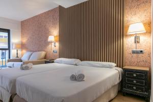 马德里H-A Aparthotel Hotel Quo的酒店客房,配有两张带毛巾的床
