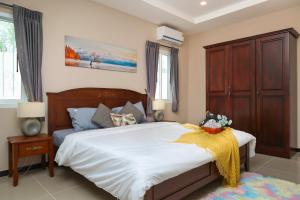 南芭堤雅CityHouse-OSCAR,pool villa 4Bedrooms-Jacuzzi-walking Street 10min的一间卧室配有一张带白色床单的大床