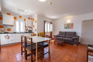 米尔芳提斯城Apartamentos Atlantico by Umbral的厨房以及带桌椅的起居室。