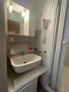 利多迪耶索罗Hotel Carinthia的浴室设有白色水槽和镜子