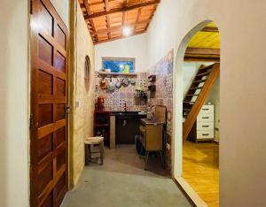 韦尔卡鲍Hospedagem Sabor Da Trilha的走廊设有拱门,通往带书桌的厨房