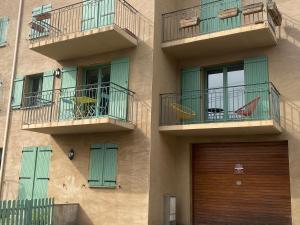 丰罗默奥代洛维亚Chaleureux appartement T4 cosy, Font Romeu Odeillo Via的一座带两个阳台和木门的建筑