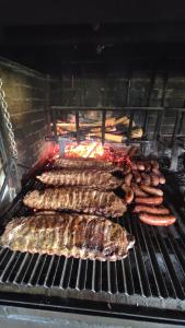 蒂内奥Pension Parrilla Casa Vicente的烤架上的肉和香肠