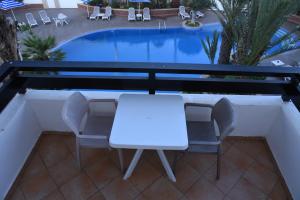 阿加迪尔金沙滩公寓酒店的游泳池旁的白色桌椅