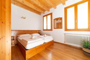 博尔索-德尔格拉帕Locanda 77的卧室配有一张大床、木地板和窗户。