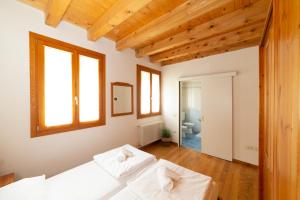 博尔索-德尔格拉帕Locanda 77的卧室设有2个白色的天花板和木制天花板。