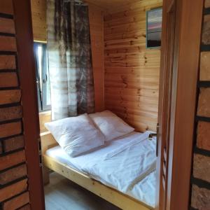雅罗斯瓦维茨Domki Letniskowe Meduza的小木屋内的一张床铺,设有一扇门