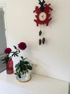 费尔德伯格Haus Anna-Marie的挂在墙上的时钟,在台上挂着鲜花