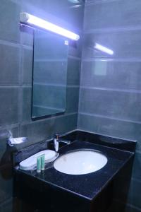 塞拉莱Alezz Suites Salalah的一间带水槽和镜子的浴室