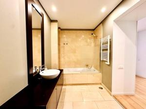 里斯本Lucky Alameda Apartment的浴室配有盥洗盆和浴缸。