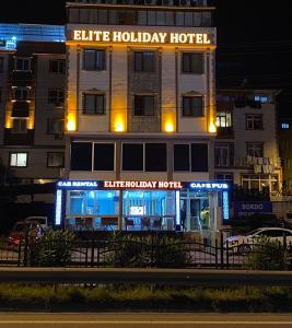 特拉布宗Elite Holiday Hotel的一座晚上拥有蓝色假日酒店的建筑