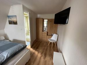 库克斯港Gästehaus Bremer的一间卧室配有一张床,墙上配有电视