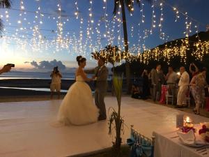 塔林甘海滩安卡天堂度假酒店的海滩婚礼上的新娘和新郎跳舞,灯光亮起