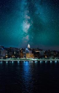 伊斯坦布尔Astra Boutique Hotel的夜空在水面上,满天星空的城市