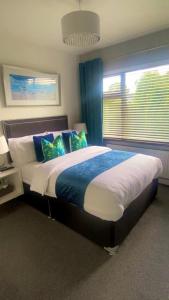库拉克洛Robin Hill Bed and Breakfast的一间卧室配有一张带蓝白色枕头的大床