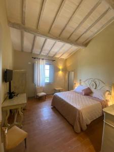 丘西Locanda Granducato的一间卧室配有一张床、一张桌子和一个窗户。