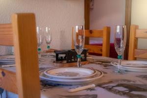 Aillon-le-JeuneLe Rossane 26m Balcon vue的一张桌子,上面有酒杯和盘子