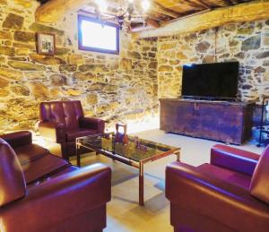 潘通Casa de Ribeira Sacra con calefacción的客厅配有两张沙发和一台电视机