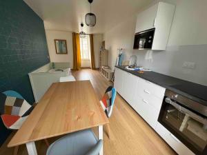 PontfarcyLa Maison des Amis en Normandie的厨房配有木桌和台面