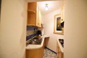 阿特拉尼Casa De Rosa的一间带水槽和炉灶的小厨房