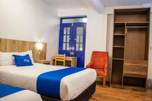 库斯科Estancia San Pedro Hotel的配有一张床和一把椅子的酒店客房