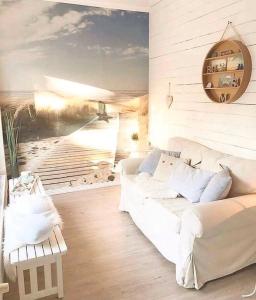 比苏姆Deichhaus No.5的客厅配有白色沙发和海滩绘画