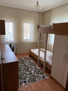 特拉布宗BEŞ YILDIZ APART的一间小房间,配有双层床和地毯