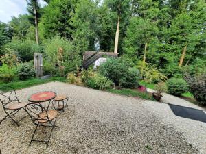 LindryAu Calme Absolu chez Nicolas的花园内带桌子和两把椅子的庭院