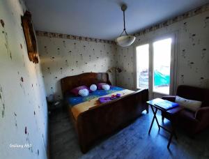 LindryAu Calme Absolu chez Nicolas的一间小卧室,配有一张床和一张桌子