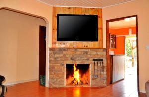 坎巴拉Pousada Encanto dos Cânions的客厅设有壁炉,上面配有电视