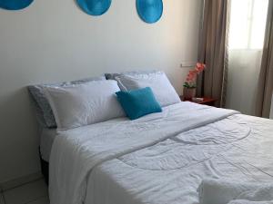 巴兰基亚Habitación en apartamento compartido al frente del cc Unico的一张白色的床,上面有蓝色的枕头