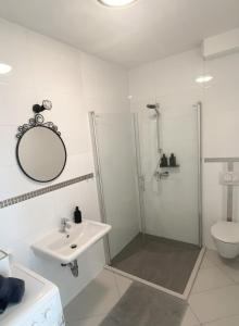 里耶卡Tijara Apartment的带淋浴和盥洗盆的白色浴室