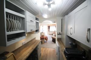 西卢港Briar Cottage的一间带白色橱柜的厨房和一间客厅