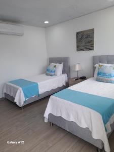 圣安德烈斯Hotel Mar de Corales By CAJASAI的配有两张床的客房内。