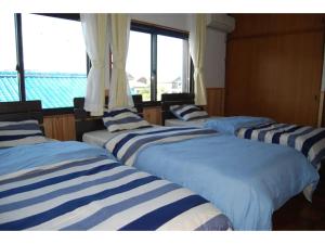 伊势市Minpaku Yagi - Vacation STAY 14700的窗户间内的四张床