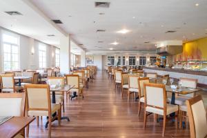 科斯塔萨乌佩Saui­pe Premium Sol All Inclusive的一间带桌椅的餐厅和一间酒吧