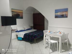 加埃塔Al Vicolo的酒店客房设有床、桌子和电视。