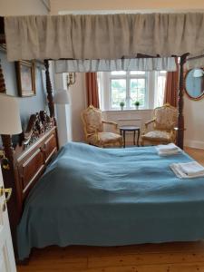 哥本哈根哥本哈根出租式酒店的一间卧室配有一张大床和两把椅子