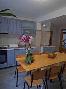那沃达利Muzicii 11 - Cozy Seaside Apartments的厨房配有带鲜花的木桌