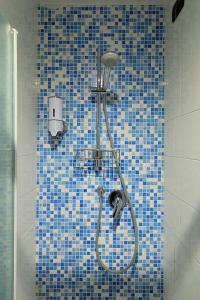 普拉托Dimora del Viaggiatore的浴室设有蓝色瓷砖墙和淋浴。