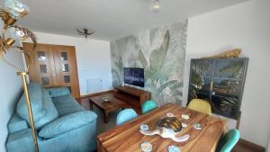 菲尼斯特雷Apartamento Capricho Finisterre Playa的客厅配有桌子和蓝色沙发