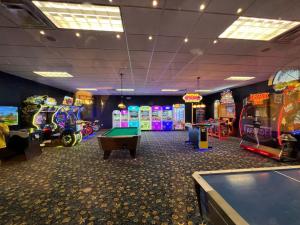 基西米Townhome w pool near Disney & Orlando Attractions的一间设有数种街机游戏和台球桌的房间