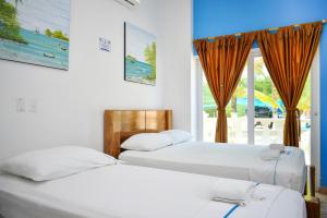 科韦尼亚斯Hotel Isla Mágica的带窗户的客房内的两张床