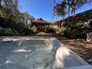 安加罗阿Te Ariki - Adults Only的一个带有房子的庭院内的热水浴池