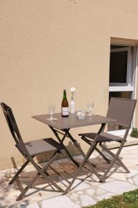 贝叶Pierre de Lune的一张带两把椅子的野餐桌和一瓶葡萄酒