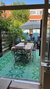 乌得勒支BeBaBops Homestay Utrecht的庭院配有桌椅和遮阳伞。