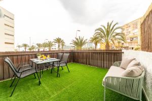 滨海罗克塔斯Trendy Homes Chumberas的阳台配有桌椅和绿色草地。