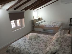 阿尔格达斯Apartamentos "El Balconico"的一间卧室设有两张床和窗户。