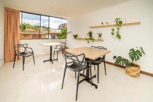 麦德林Experiencia Única Habitación Privada en Medellín A的一间带桌椅和窗户的用餐室