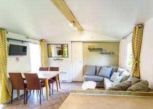翁赞Mobil-home 6/8 personnes - Camping Siblu **** Domaine de Dugny的客厅配有沙发和桌子